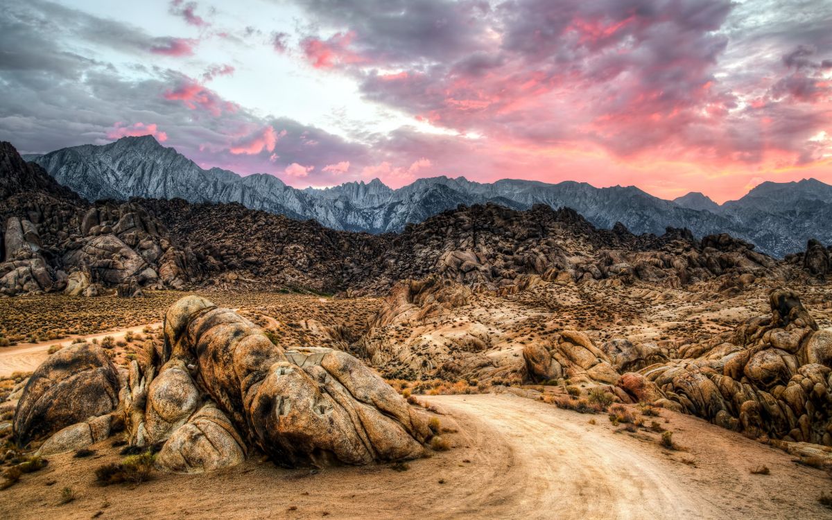 brown and black rock formation under white clouds