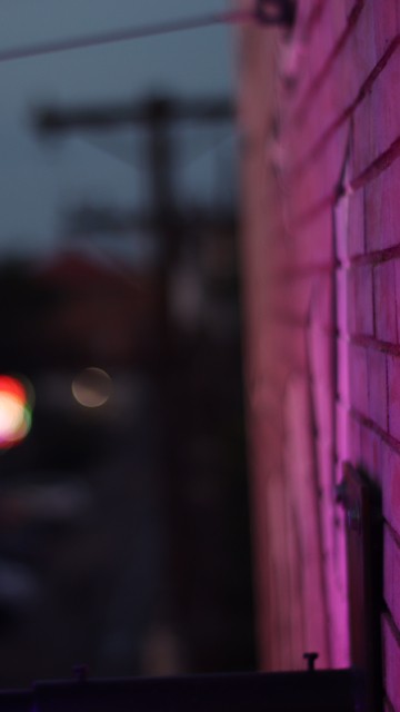 Image purple light on brown brick wall during night time