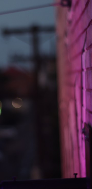 Image purple light on brown brick wall during night time