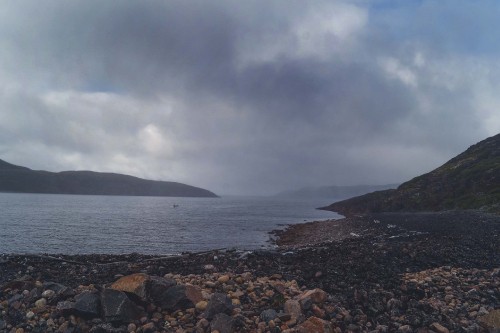 Image body of water near mountain under cloudy sky during daytime