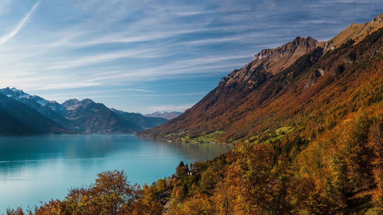 Montaña Verde y Marrón Junto al Lago Bajo un Cielo Azul Durante el Día. Wallpaper in 7680x4320 Resolution